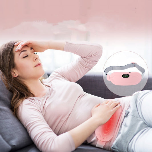 Woman relaxing with the electric menstrual warm belt for pain relief and abdominal massage during her period.